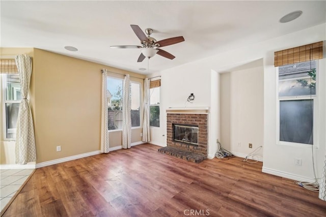 unfurnished living room with a brick fireplace, ceiling fan, and hardwood / wood-style flooring