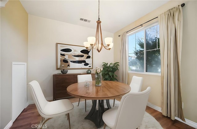 dining room featuring dark hardwood / wood-style floors and an inviting chandelier