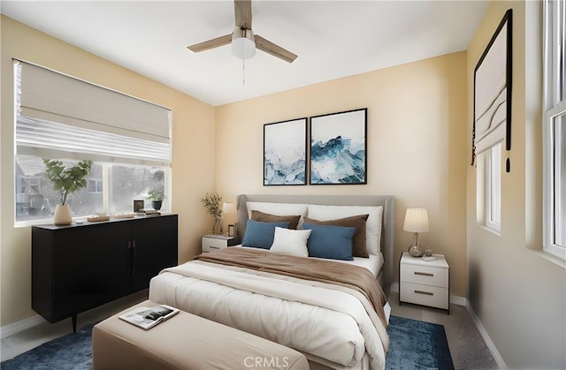 carpeted bedroom featuring ceiling fan and multiple windows