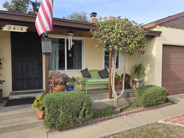 entrance to property featuring a porch and a garage