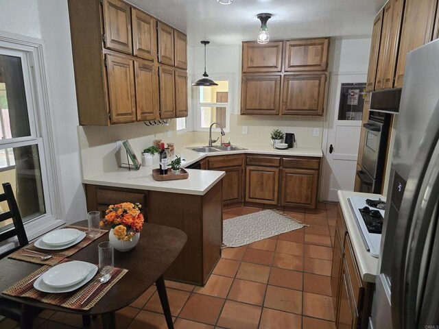 2416 J Ave, National City, CA 91950 - kitchen with a sink, freestanding refrigerator, brown cabinetry, and a peninsula