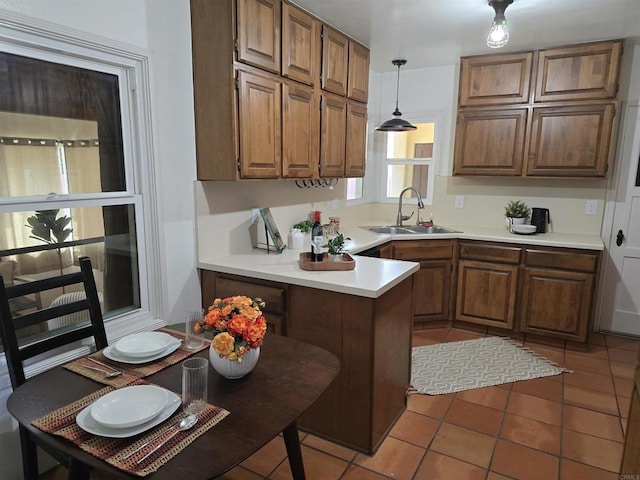 2416 J Ave, National City, CA 91950 - kitchen featuring a sink, a peninsula, light countertops, brown cabinetry, and tile patterned flooring