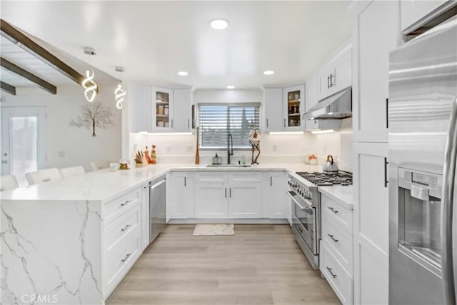 kitchen featuring pendant lighting, white cabinets, appliances with stainless steel finishes, sink, and kitchen peninsula