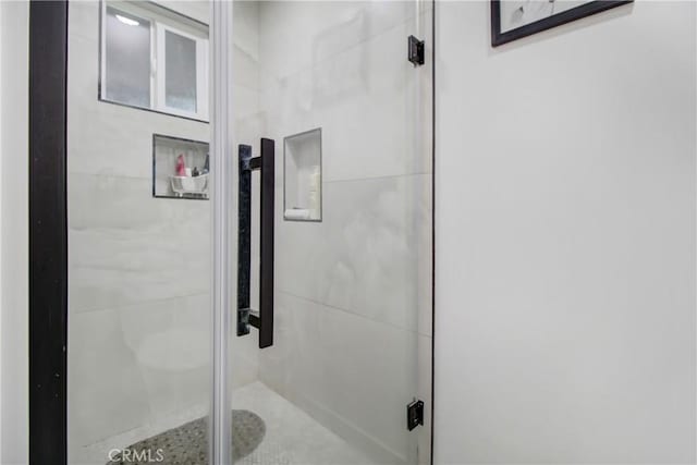 bathroom with a shower with door