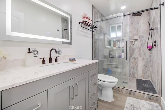 bathroom with toilet, a shower with door, hardwood / wood-style flooring, and vanity