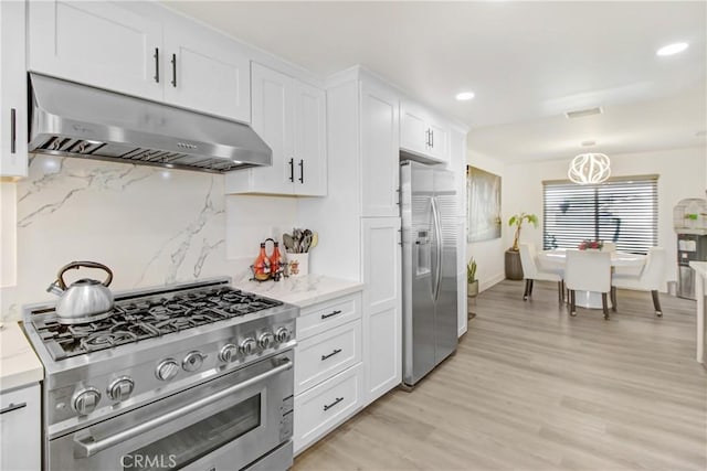 kitchen featuring white cabinetry, backsplash, stainless steel appliances, and exhaust hood