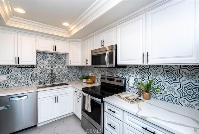 kitchen with white cabinetry, stainless steel appliances, tasteful backsplash, sink, and light tile patterned floors