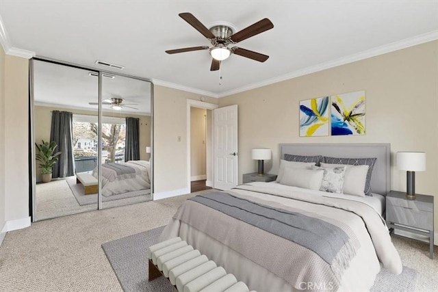 bedroom featuring ceiling fan, a closet, crown molding, and carpet flooring