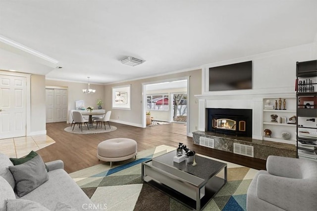 living room featuring crown molding, a chandelier, and hardwood / wood-style flooring