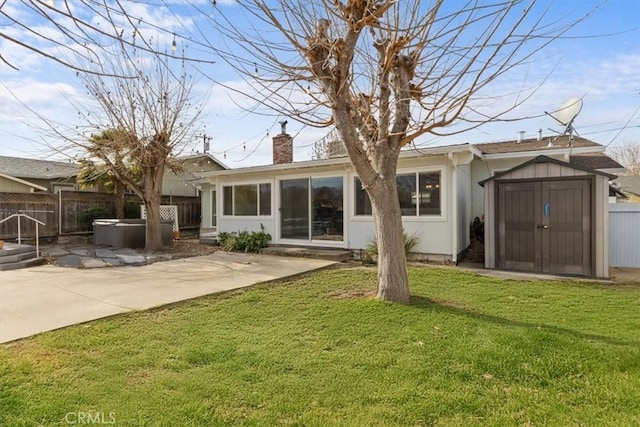 rear view of property with a storage shed, a patio area, and a yard