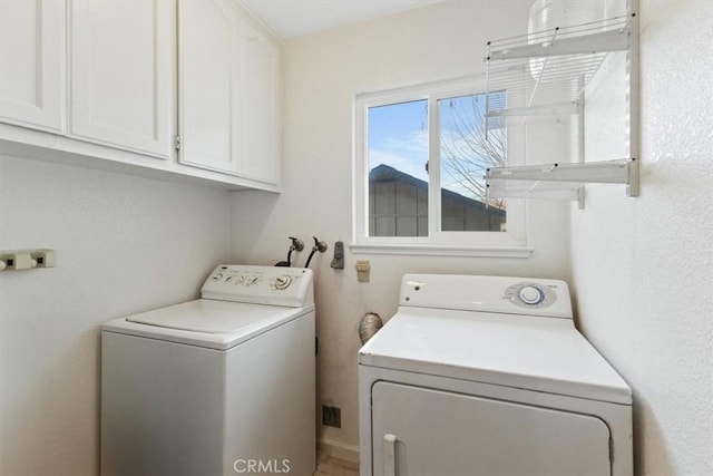 washroom featuring cabinets and independent washer and dryer