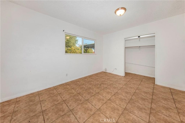 unfurnished bedroom with a closet and light tile patterned flooring