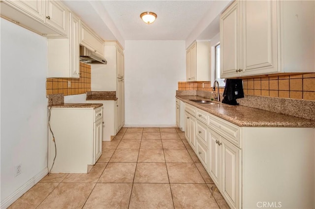 kitchen featuring extractor fan, light tile patterned floors, decorative backsplash, and sink