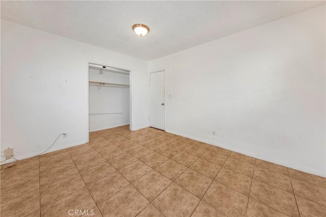 unfurnished bedroom featuring light tile patterned floors and a closet