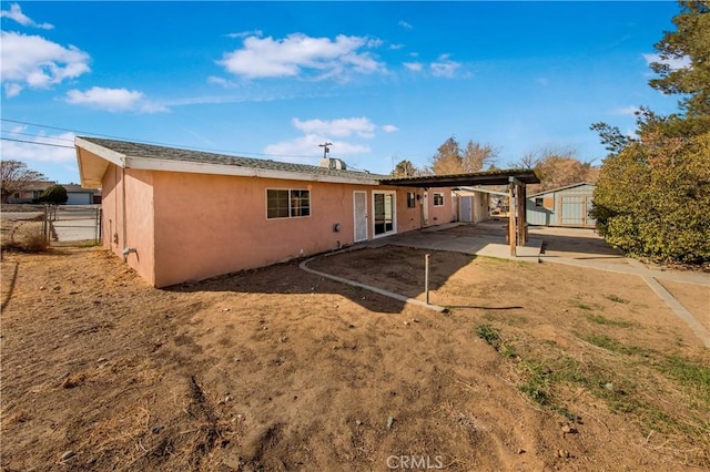 rear view of property featuring a storage unit