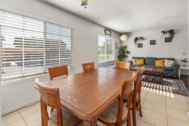 tiled dining space with ceiling fan and a textured ceiling