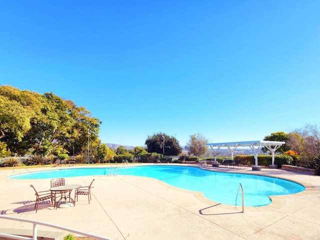 view of pool with a pergola and a patio