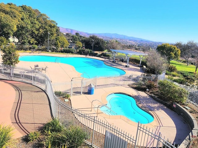 view of pool with a patio area and a mountain view