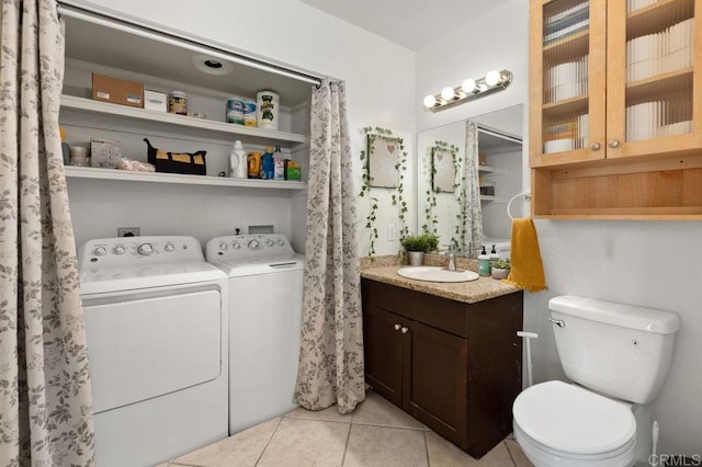 bathroom with toilet, vanity, tile patterned flooring, and separate washer and dryer