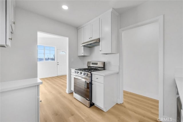 kitchen featuring stainless steel gas stove, white cabinetry, and light hardwood / wood-style floors