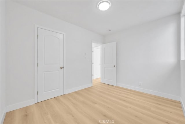 unfurnished bedroom with a closet and light wood-type flooring