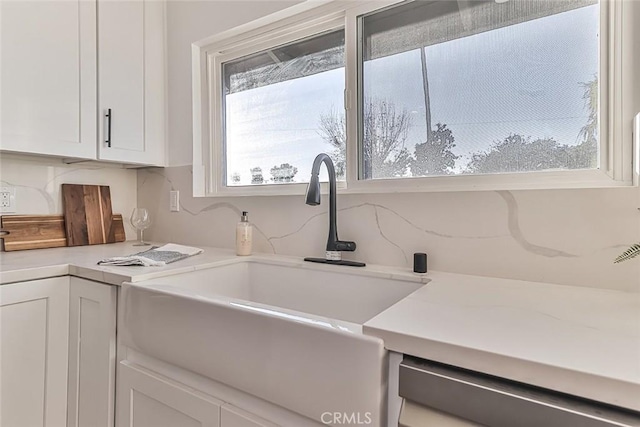 kitchen with white cabinets, dishwasher, and sink