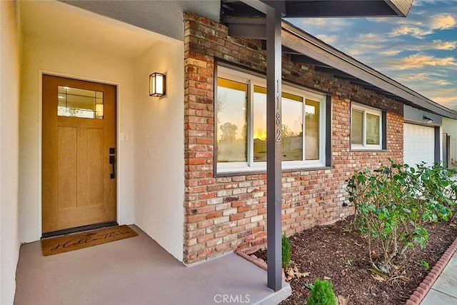 exterior entry at dusk featuring a garage