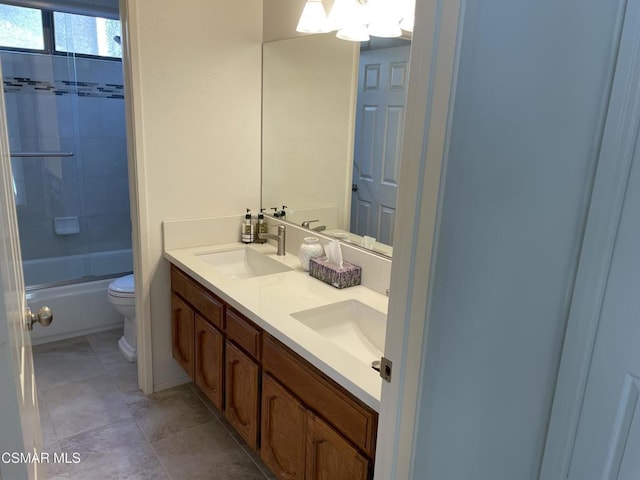 full bathroom with bath / shower combo with glass door, toilet, and vanity