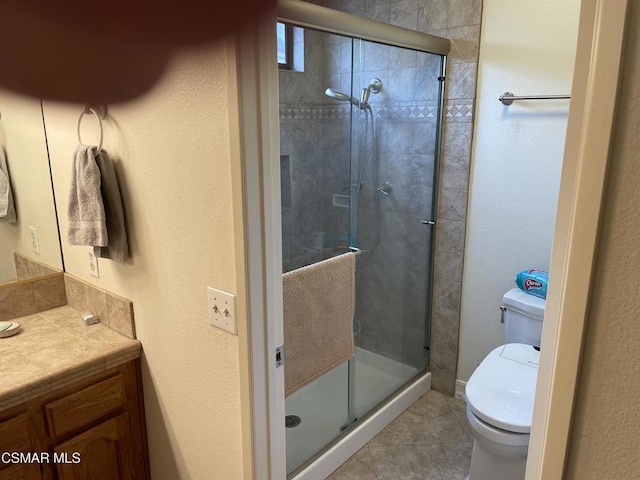 bathroom with toilet, tile patterned floors, walk in shower, and vanity