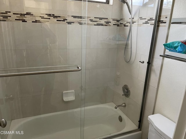 bathroom with toilet and enclosed tub / shower combo