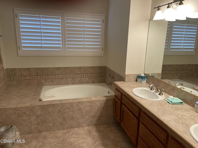 bathroom with tiled bath, tile patterned floors, and vanity