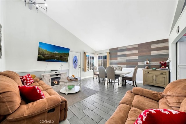 living room featuring high vaulted ceiling and a notable chandelier