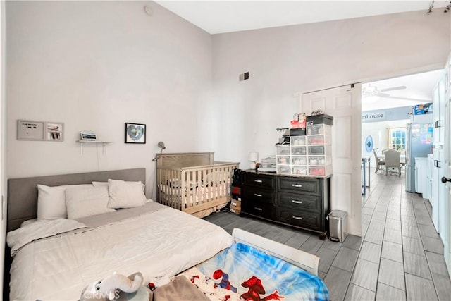 bedroom featuring ceiling fan and stainless steel fridge