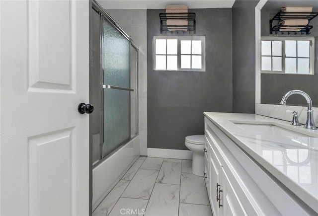 full bathroom featuring toilet, vanity, and shower / bath combination with glass door