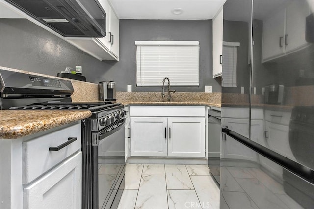 kitchen featuring wall chimney range hood, white cabinets, black range with gas cooktop, and dark stone countertops