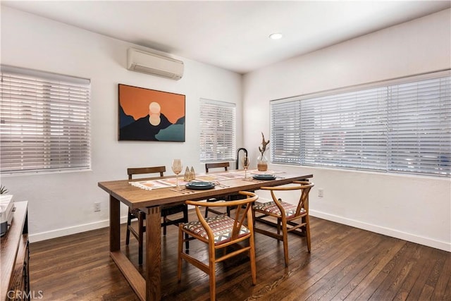 dining room featuring an AC wall unit and dark hardwood / wood-style floors