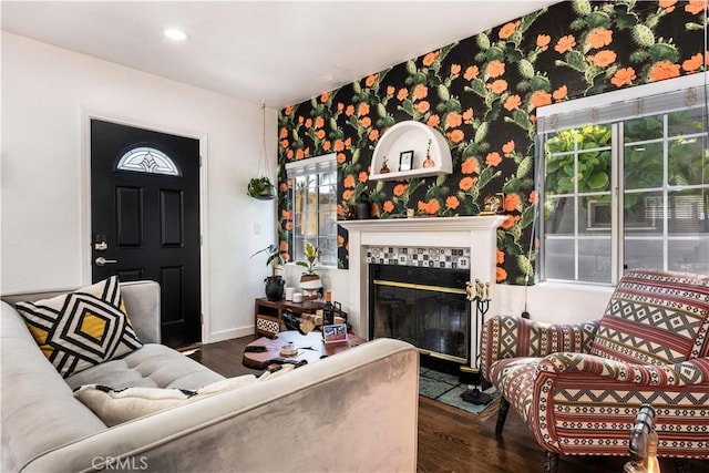 living room featuring a tiled fireplace and dark hardwood / wood-style flooring