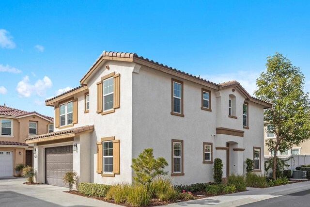 mediterranean / spanish-style home featuring a garage and central AC