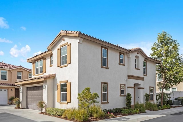 mediterranean / spanish-style house with a garage and central air condition unit