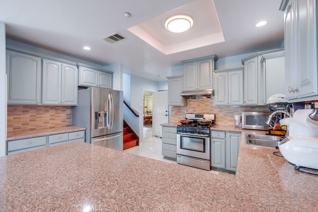 kitchen with light countertops, visible vents, backsplash, appliances with stainless steel finishes, and under cabinet range hood