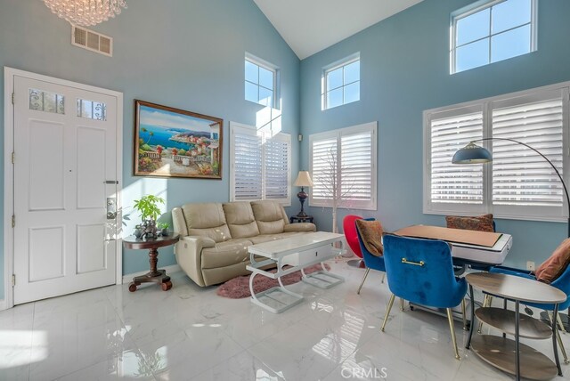 living room with high vaulted ceiling and a notable chandelier