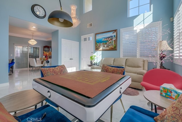 rec room with marble finish floor, visible vents, and a high ceiling