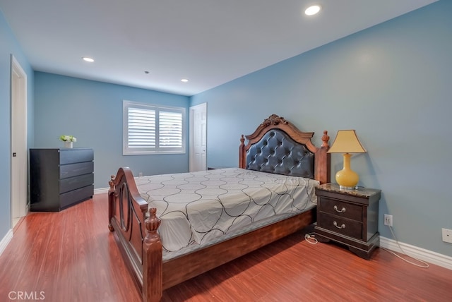 bedroom featuring baseboards, wood finished floors, and recessed lighting