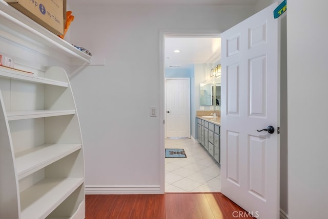 spacious closet featuring light wood finished floors and a sink