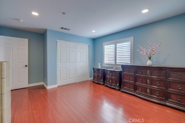 unfurnished bedroom with a closet, recessed lighting, visible vents, and light wood-style floors