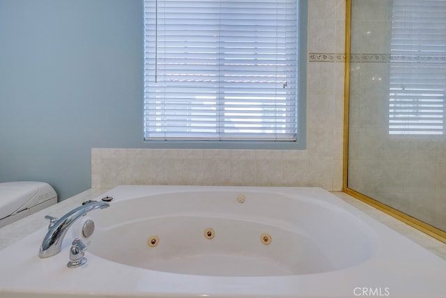 full bathroom with toilet and a whirlpool tub