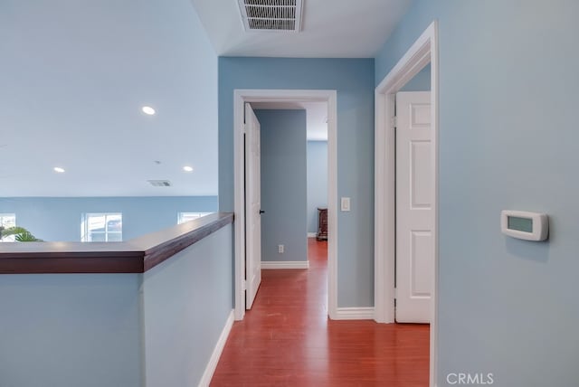 corridor featuring baseboards, visible vents, wood finished floors, and recessed lighting