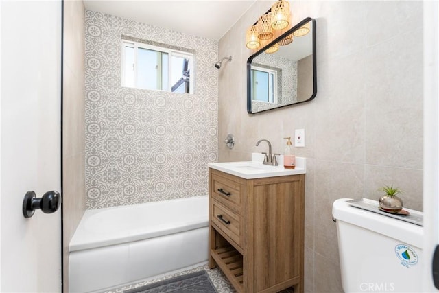 full bathroom featuring vanity, toilet, shower / bath combination, and tile walls