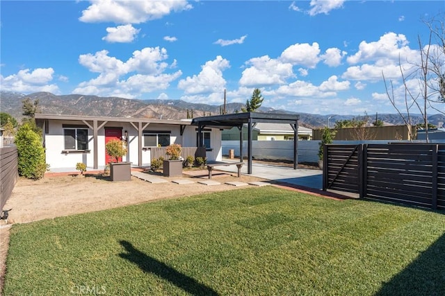 rear view of property featuring a lawn and a mountain view