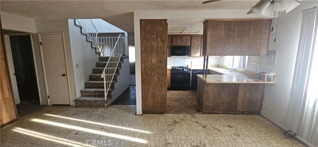 kitchen with a textured ceiling, kitchen peninsula, and range with gas stovetop